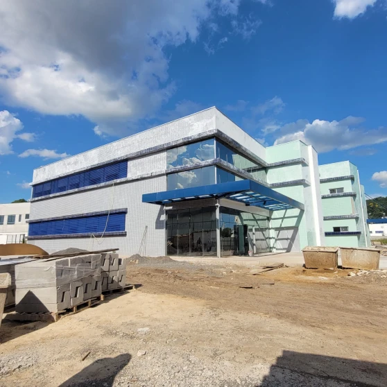 Fachada comercial em pele de vidro de obra industrial Guaracal em Guarapuava